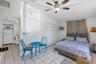Tile flooring, vaulted ceilings, ceiling fan with integrated lighting, and louvered double-door closet