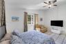 Room featuring ceramic tile flooring, multi-pane window, and ceiling fan with integrated light fixture