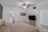 Vaulted ceiling featuring a central multi-blade ceiling fan with integrated light fixture and large-format tile flooring