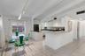 Vaulted ceilings with exposed beams, tile flooring, breakfast bar, and track lighting