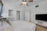Vaulted ceilings, ceiling fan with light fixture, built-in cabinetry, and closet with louvered doors