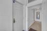 Six-panel interior door with satin nickel hardware, transom window, and neutral tile flooring