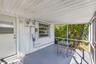 Screened-in porch featuring a corrugated metal ceiling, painted concrete flooring, and horizontal sliding windows