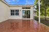 Screened-in lanai featuring tile flooring, sliding glass doors with a transom window, and white metal framing