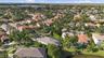 Aerial perspective featuring mature tropical landscaping, tile roof construction, and a water frontage location