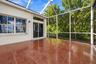 Screened-in patio featuring tile flooring, aluminum framing, a sliding glass door, and exterior sconce lighting