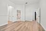 Interior space featuring wood-finish flooring, high ceilings, and multi-panel interior doors