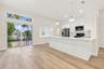 Kitchen featuring a quartz-topped island, white cabinetry, wood-finish flooring, recessed lighting, and sliding glass doors with a transom window