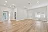 Open-concept room featuring wood-finish flooring, recessed lighting, white French doors with glass panels, and large windows with horizontal blinds