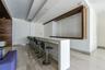 Open-concept interior featuring floor-to-ceiling glass wall panels, polished large-format tile flooring, and recessed ceiling lighting