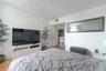 Wood-finish flooring and wall-mounted rectangular mirror with a dark frame
