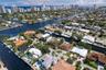 Waterfront property featuring a private boat dock, swimming pool, manicured lawn, and hardscaped patio area