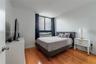Room featuring wood-finish flooring, floor-to-ceiling windows with black frames, and smooth white walls