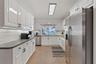 Open-concept living space featuring neutral ceramic tile flooring, recessed lighting, and large glass sliding doors