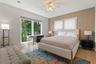 Open-concept living space featuring neutral tile flooring, recessed ceiling lighting, and expansive dual sliding glass doors