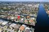 Aerial perspective of waterfront property featuring a private swimming pool, deep-water dockage, and direct canal access