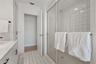 Entryway featuring a built-in wood-finish display shelf, recessed ceiling lighting, tile flooring, and vertical blinds