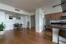 Wood-finish flooring, kitchen with dark stone-finish countertops, stainless steel appliances, track lighting, and built-in wall mirror
