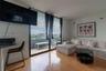 Floor-to-ceiling sliding glass doors, private balcony, wood-finish flooring, and wall-mounted lighting