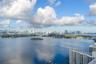 Aerial perspective featuring an expansive cityscape, horizon-spanning skyline, and distant coastal waters under a vast sky