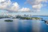 Aerial perspective featuring expansive open water, island topography, and a metropolitan skyline backdrop