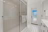 Open-concept interior featuring large-format tile flooring, recessed lighting, and multiple sliding glass doors providing outdoor access