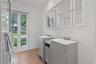 Kitchen featuring white cabinetry, subway tile backsplash, solid-surface countertops, stainless steel dishwasher, and tile flooring