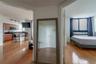 Kitchen featuring wooden cabinetry, dark countertops, a built-in microwave, and track lighting, complemented by wood-finish flooring and large windows