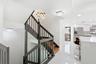 Modern kitchen featuring stainless steel appliances, white cabinetry, and beatifyl staircase