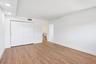 Spacious interior with wood-finish flooring, recessed lighting, and white walls