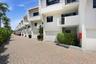 Stucco exterior with white finish, integrated private balconies, attached garages, and a paver driveway