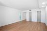 Spacious interior with wood-finish flooring, white walls, and recessed ceiling lighting, walk-in closet