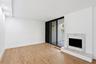 Wood-finish flooring, recessed lighting, and a white fireplace surround with a stone hearth