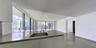 Kitchen island with a solid-surface countertop, under-mount stainless steel sink, flat-panel cabinetry, floor-to-ceiling windows, and large-format til