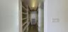 Walk-in closet featuring floor-to-ceiling built-in shelving, multiple hanging rods, and wood-finish flooring