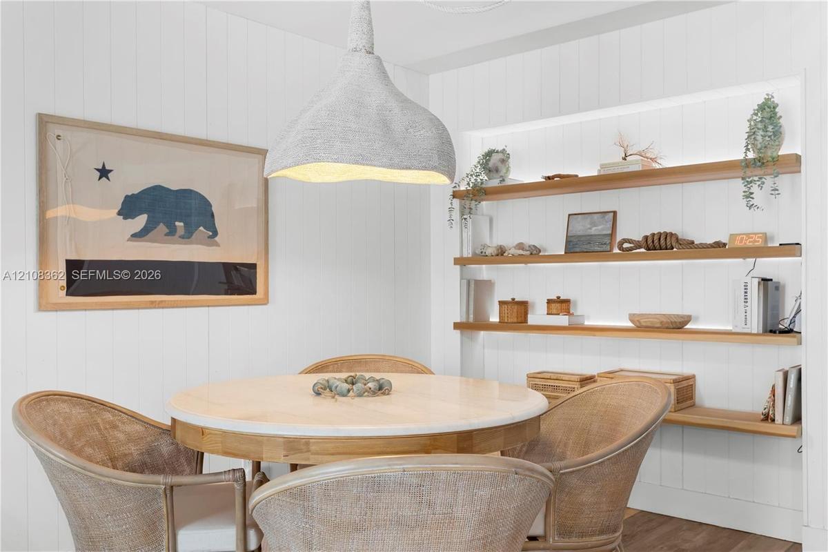 Built-in wall niche with recessed shelving, integrated linear lighting, and vertical plank wall paneling, complemented by a textured organic-form pend