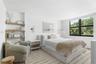 Vertical tongue-and-groove wall paneling, built-in recessed shelving, wall-mounted swing-arm light fixtures, and a multi-pane window
