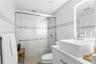 Walk-in shower with sliding glass doors, white subway-style wall tiling, decorative mosaic tile inlay, modern vessel sink with chrome faucet, and inte