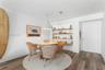 Vertical white plank wall paneling, integrated recessed shelving with under-shelf lighting, and wood-finish flooring