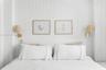 Vertical plank wood wall paneling with dual brass-finish wall-mounted sconces featuring textured shades