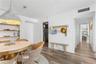 Vertical wood-plank wall paneling, wide-plank wood-finish flooring, built-in open shelving, and a large metal dome pendant light
