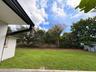 Backyard featuring an expansive lawn, mature tree canopy, and wood fencing