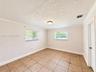 Neutral interior featuring tile flooring, crown molding, and two windows with horizontal blinds