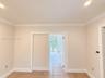 Neutral-toned interior space featuring crown molding, recessed lighting, and tile flooring with decorative inlay accents