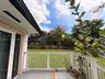 Outdoor deck featuring white wooden railings, grey plank flooring, and dual glass-paneled exterior doors