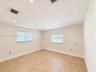 Neutral-toned tile flooring, recessed ceiling lighting, and dual windows with horizontal blinds