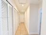 Hallway featuring ceramic tile flooring, multiple white louvered closet doors, and recessed lighting
