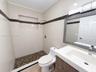 Bathroom featuring large-format wall tile with decorative stone inlay, a walk-in shower with stone mosaic flooring and built-in recessed shelving, and
