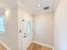 Entryway featuring a white door with an oval glass insert, recessed lighting, crown molding, and stone tile flooring
