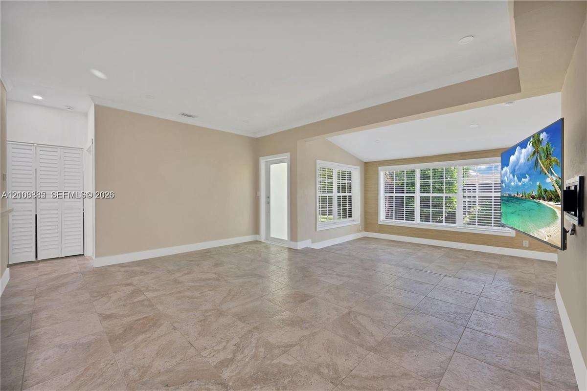 Neutral tile flooring, recessed lighting, crown molding, multi-pane windows, and white louvered closet doors
